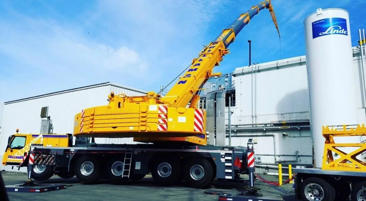 A large crane is parked on the side of a road.