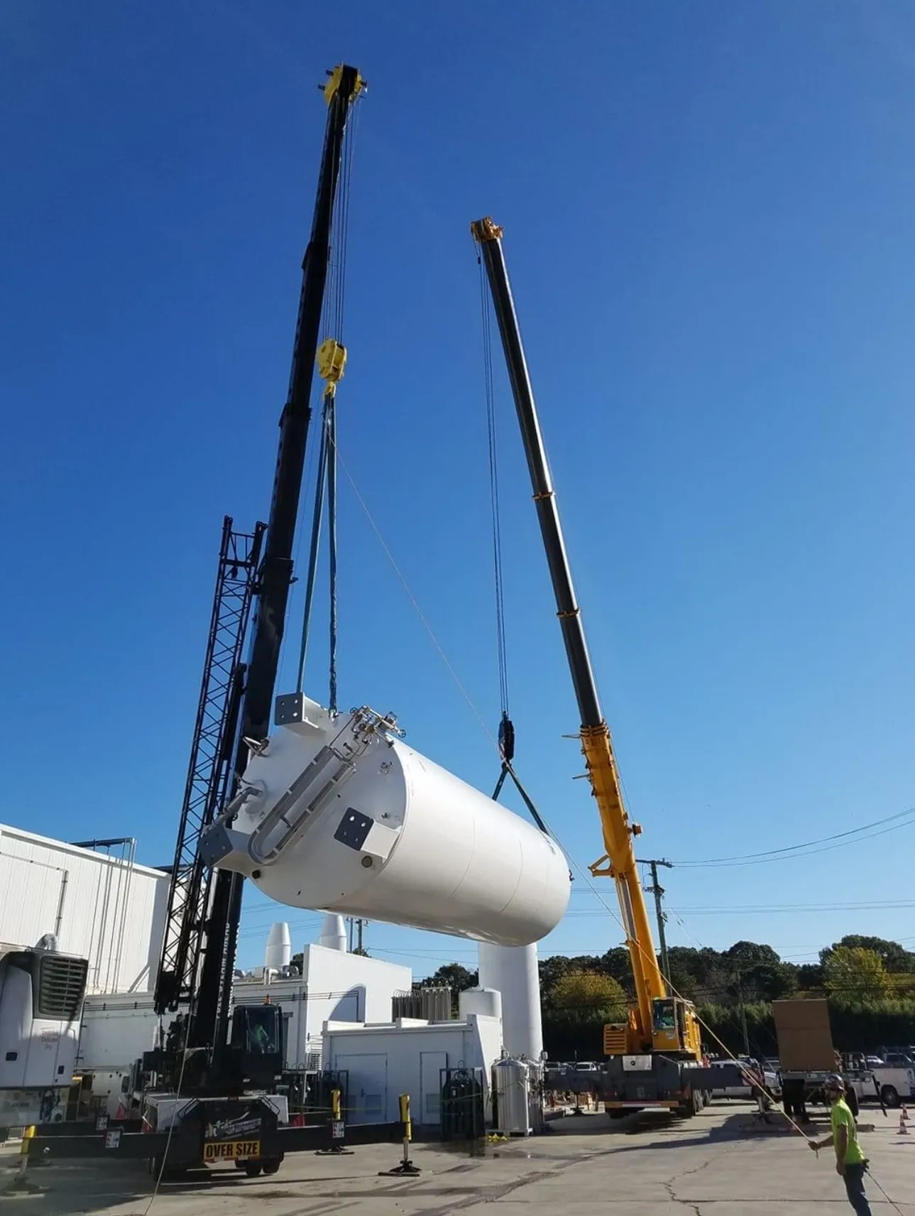 A crane is lifting a tank from the ground.