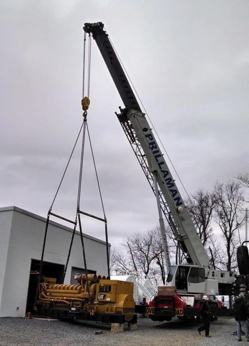 A crane is being used to lift a large piece of machinery.