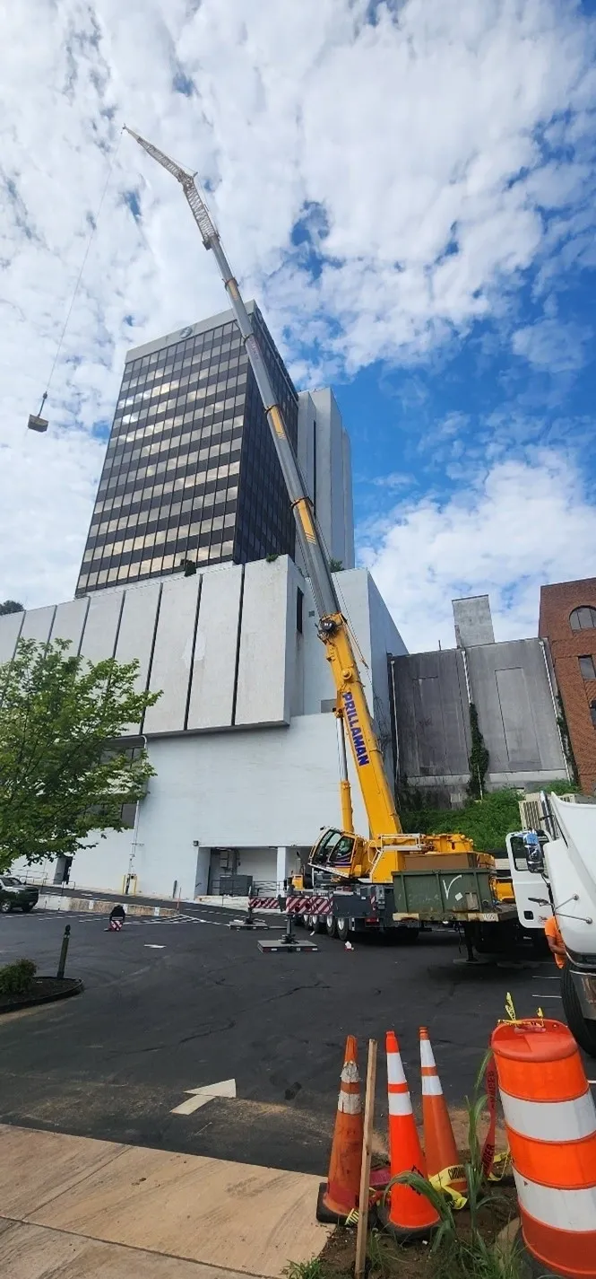 A crane is in front of a tall building.