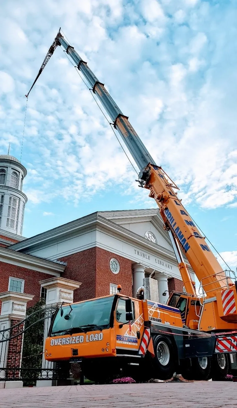 A crane is in front of a building.