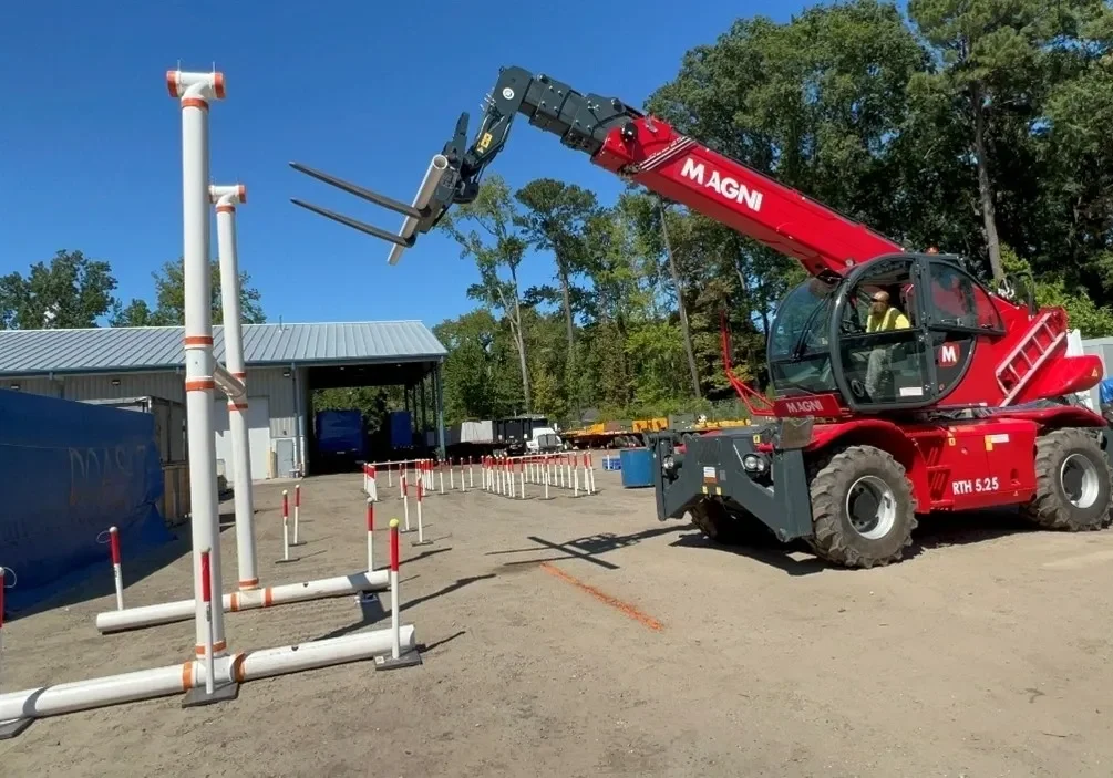 A crane is lifting a pipe into the ground.